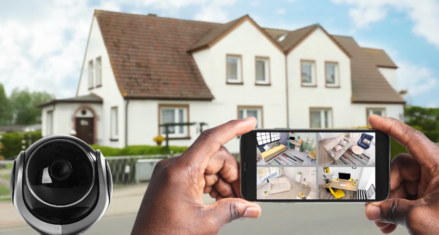 Man holding mobile device and checking footage from security cameras