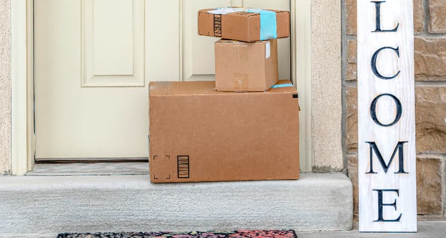 Boxes by the door of a residence with a welcome sign in Tyler